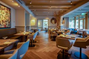 - un restaurant avec des tables et des chaises dans une salle dans l'établissement Villa de Duinen - Adults Only, à Noordwijk aan Zee