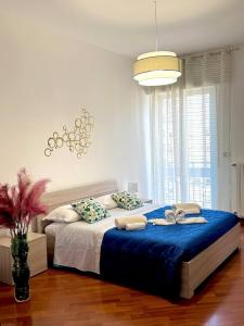 a bedroom with a large bed with a blue blanket at Antares In Puglia in Monopoli