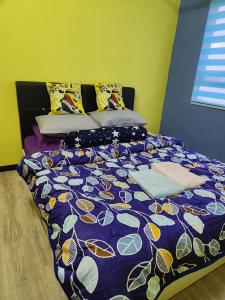 1 cama con edredón y almohadas de color púrpura en Triple H Minionstay Kuala Terengganu, en Kuala Terengganu