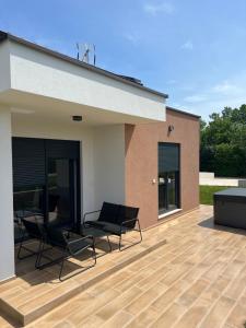 a patio with two chairs and a building at Modern Home Ula in Brtonigla