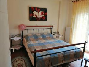 a bedroom with a bed and a painting on the wall at Ήσυχη μονοκατοικία κοντά στη θάλασσα!!! in Polichnítos