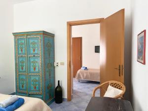 1 dormitorio con armario azul y verde junto a la cama en Rosa Dei Venti Marettimo, en Marettimo