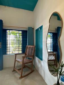 a mirror and a chair in a room at IRINI Boutique Homestay Mui Ne in Mui Ne