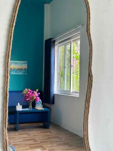 a mirror in a room with a table and a window at IRINI Boutique Homestay Mui Ne in Mui Ne