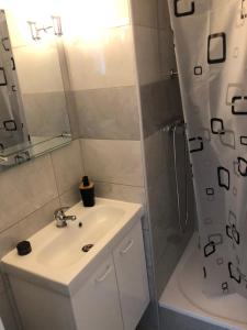 ein weißes Badezimmer mit Waschbecken und Dusche in der Unterkunft Evry Time in Courcouronnes + 12 Fotos