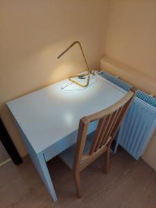 uma secretária branca com um candeeiro e uma cadeira em Apartament Baltic 2 rooms / pokoje em Świnoujście