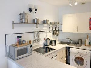 a kitchen with a stove and a microwave at Rock Cottage in Ardentinny