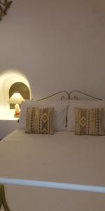 una gran cama blanca con almohadas. en Fotinos Houses, en Oia