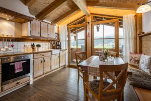 a kitchen with wooden cabinets and a table and chairs at Ferienwohnungen Reich in Schönau am Königssee