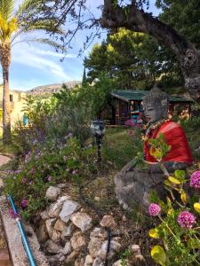 a statue in a garden with flowers and a house at casa India in Alicante