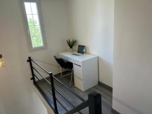 a room with a desk with a laptop computer on it at House with terrace près de l'Aéroport RoissyCDG - Tour Eiffel - Champs Elysée - Paris - Aéroville centre commercial - Parc Astérix - Disneyland Paris - Mer de sable - Châteaux de Chantilly et Ecouen - Parc des expositions Villepinte - Le Bourget in Le Thillay