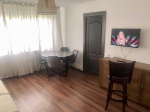 a dining room with a table and chairs and a television at Silene Studio in Craiova