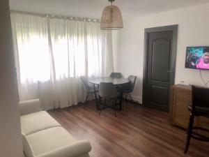 a living room with a table and chairs and a couch at Silene Studio in Craiova