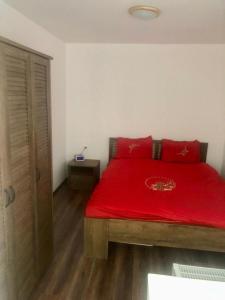 a bedroom with a red bed with a wooden floor at Silene Studio in Craiova