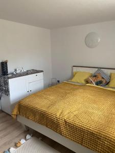 1 dormitorio con cama amarilla y armario blanco en Petit Appartament, en Kowary