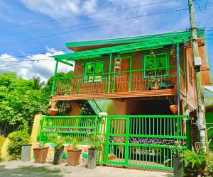 una casa con finiture verdi e balcone di Ianka & Enio Dream Suites a Digos