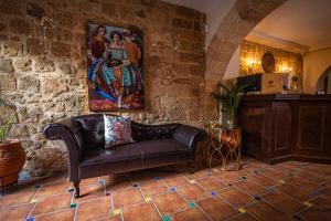 a leather couch in a room with a painting on the wall at APRIL Luxury Suites in Rhodes Town