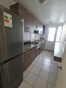 uma cozinha com um frigorífico de aço inoxidável e armários de madeira em Apartamento Los Andes em Los Andes