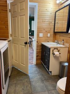 un bagno con lavandino, servizi igienici e porta di Strawberry River Ranch Cabin On 700 Acre Ranch a Horseshoe Bend