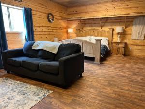 un soggiorno con divano e letto di Strawberry River Ranch Cabin On 700 Acre Ranch a Horseshoe Bend