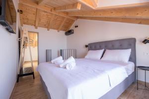 a bedroom with a large bed with white sheets at Stone house Marinko - Free Beach Parking in Tučepi
