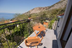 a balcony with two chairs and a table and a view at Stone house Marinko - Free Beach Parking in Tučepi