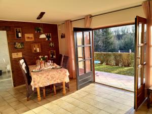 a dining room with a table and a sliding glass door at CasaVitis "Erholung am Weinberg" in Lontzen