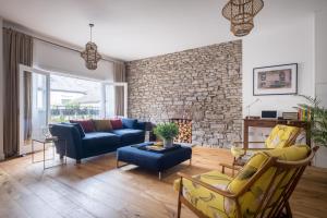 a living room with a blue couch and a brick wall at The Artists Loft - Luxury Lake District Apartment with Private Parking in Kendal