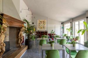 a restaurant with green chairs and tables and a fireplace at Relais Borghetto in Valeggio sul Mincio