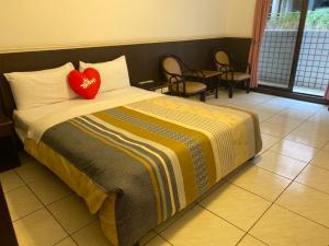 a bedroom with a bed with a red heart pillow at Zhiben Hotspring in Wenquan