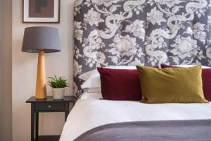 1 dormitorio con 1 cama con papel pintado de flores azul y blanco en The Artists Loft - Luxury Lake District Apartment with Private Parking, en Kendal