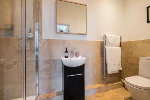 a bathroom with a sink and a shower at The Artists Loft - Luxury Lake District Apartment with Private Parking in Kendal
