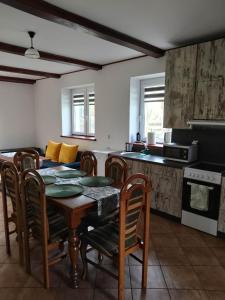 uma cozinha e sala de jantar com mesa e cadeiras em Siedlisko Kapice em Grajewo
