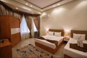 a hotel room with two beds and two windows at NEW CITY VIEW in Cairo