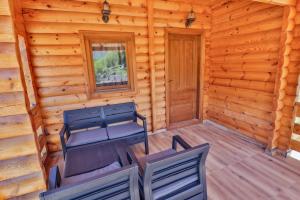 a room with two chairs and a table in a log cabin at Vinogradina Eco Vukčević in Virpazar
