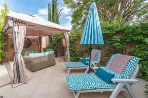 een patio met 2 stoelen en een parasol bij Luxury 2 Bedroom Self Catering Apartment in Pinoso