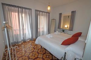 ein Schlafzimmer mit einem großen weißen Bett und einem Spiegel in der Unterkunft La Cerona N°1 in Colunga