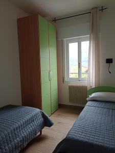 Schlafzimmer mit einem Bett und einem Fenster in der Unterkunft EderaHouse in Cerano d'Intelvi