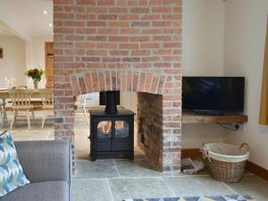 a brick fireplace with a stove in a living room at Cowslip - Uk13138 in Barnby Moor