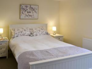 a bedroom with a large white bed with two night stands at Cowslip - Uk13138 in Barnby Moor