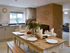 cocina con mesa de madera y chimenea en Cowslip - Uk13138 en Barnby Moor