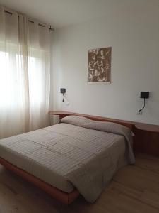 ein Schlafzimmer mit einem Bett und zwei Lampen an der Wand in der Unterkunft EderaHouse in Cerano d'Intelvi