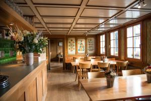 Rifferswil的住宿－3 Sterne Boutique Gasthaus Pöstli，餐厅设有木桌、椅子和窗户。
