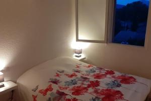 ein Schlafzimmer mit einem Bett mit einer Blumendecke darauf in der Unterkunft la Casa del Sol -2 à 5 pers - 5km de Saint Tropez in Gassin