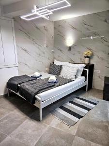 Bett in einem Zimmer mit einer Marmorwand in der Unterkunft Studio Carmen in Piran