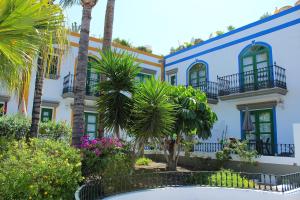 un bâtiment avec des palmiers en face de celui-ci dans l'établissement Sunny Puerto de Mogan, à Puerto de Mogán