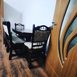 a dining room with a table and chairs and a door at La bunici in Baia Mare