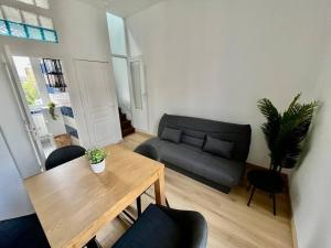 salon ze stołem i kanapą w obiekcie L évasion w Amiens +4 zdjęcia