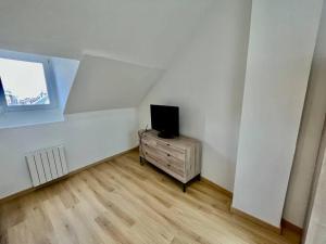 pokój z telewizorem na komodzie w pokoju w obiekcie L évasion w Amiens
