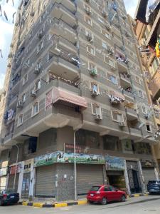 een hoog gebouw met auto's geparkeerd voor het bij Cozy in Giza 2 bedroom apartment in Caïro